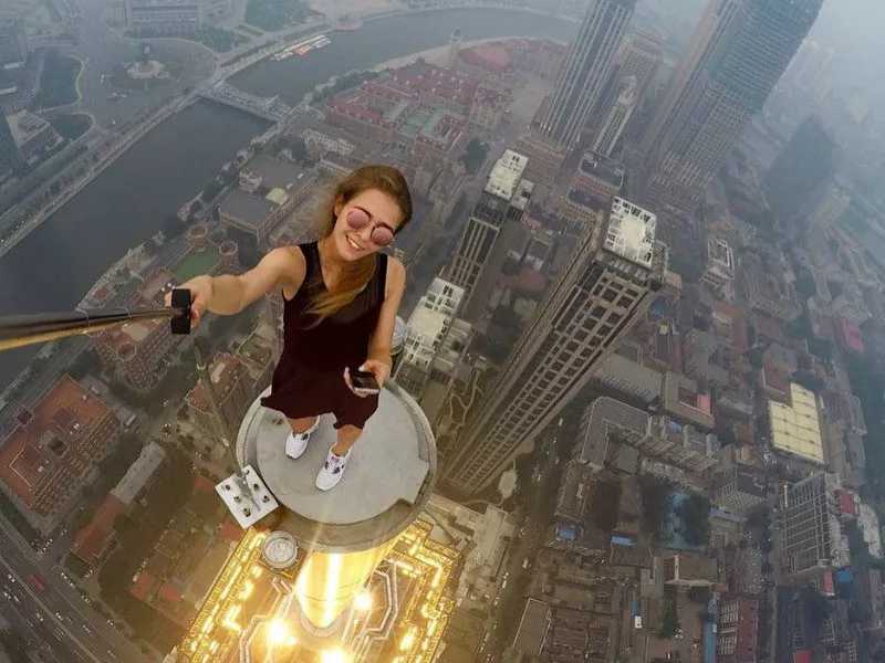 selfie sendo feita por uma mulher no topo de um prédio